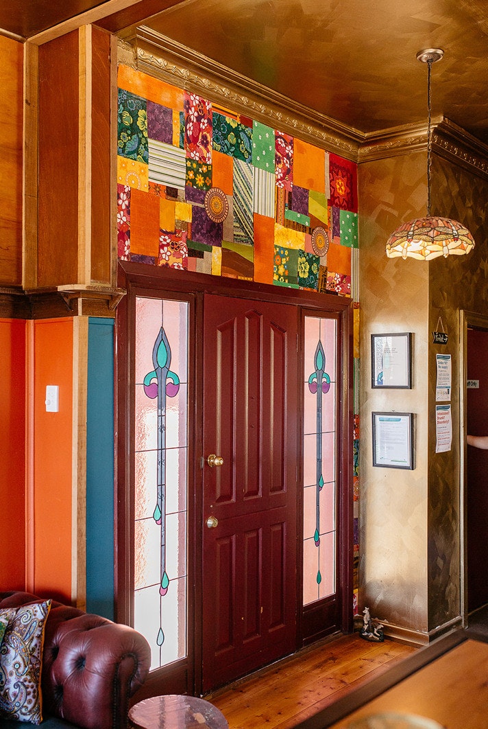 Stained-glass door entryway to colourful farmhouse.